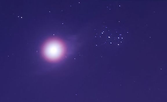 Venus rodeado de una aureola y una tenue nube, con las Pléyades a la derecha